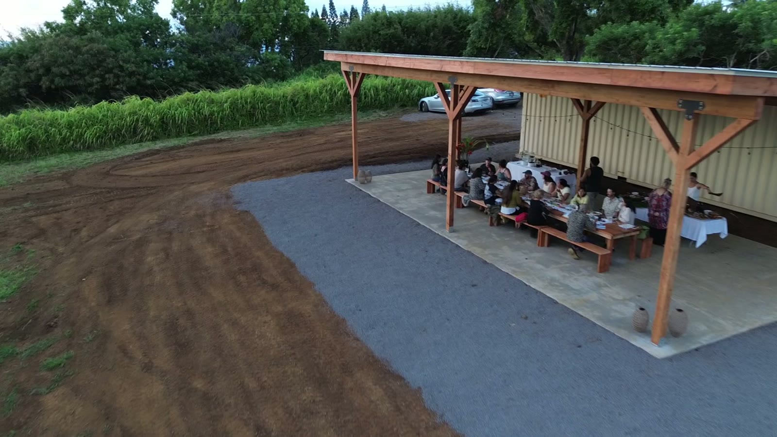 Drone view of guests at the long table under the open-air pavilion